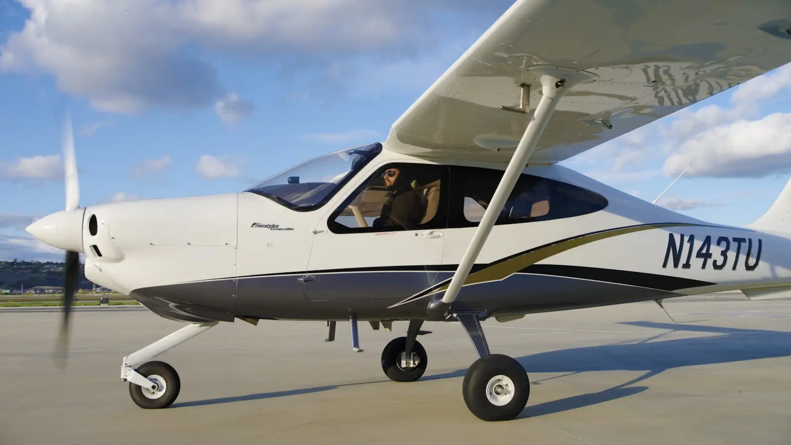 A small white airplane on an airport tarmac.